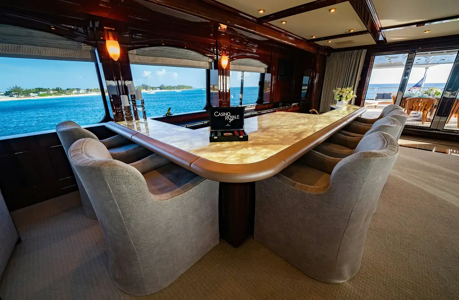 Phygital Group Spacious yacht lounge with a curved bar-style table, gray upholstered chairs, large windows, and ocean view. Full Service Marketing Agency
